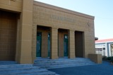 A view towards the pillared entrance of a yellow sandstone Council Chambers building  