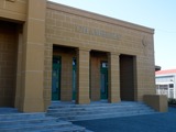 A view towards the pillared entrance of a yellow sandstone Council Chambers building  