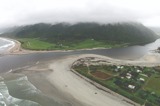 Aerial view of a small coastal settlement at the mouth of a river on a cloudy day  