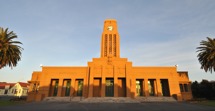 Stone clocktower Council chambers and palm trees