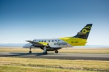 A small tuboprop aircraft taxiing on a runway on a sunny day