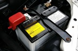 A car battery showing terminals and safety notice stickers