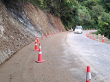 Rural road being widened in preparation for a retaining wall below it