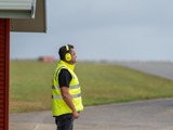 Airport staff on runway in front of building