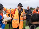 Person in raincoast instructing group