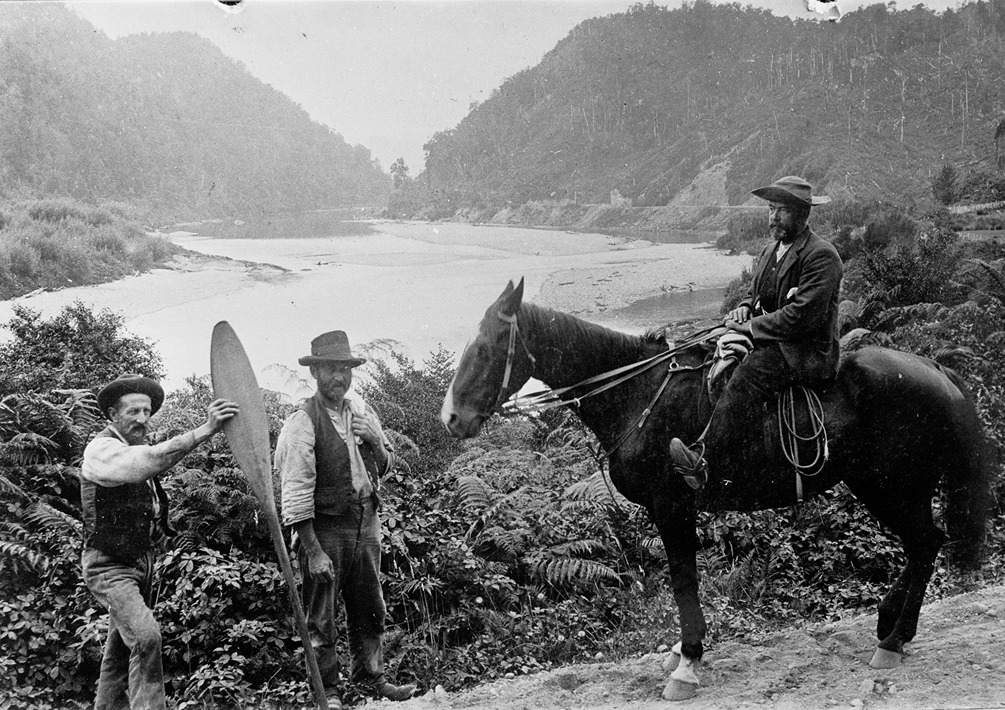 Black and white photograph of 3 men and a horse overlooking the Buller river